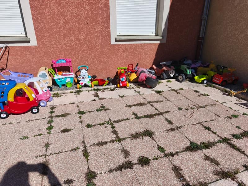 Porteurs, trotteurs, petites voitures et chariots alignés sur la terrasse de la maison